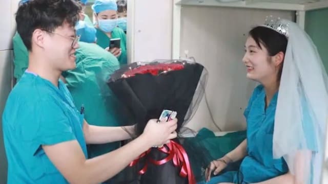 中国医护情侣并肩战疫 身穿手术服在医院完婚