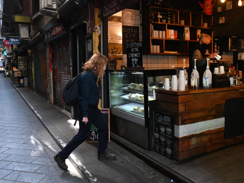 A woman walks into a cafe on a normally busy laneway in the central business district in Melbourne on Aug 6, 2020. Australia's second city Melbourne entered a more restrictive six-week lockdown on Aug 6, sparking a fresh wave of anxiety and confusion over ever-tougher regulations.