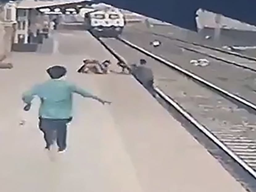 This video frame grab taken from footage released on April 20, 2021 shows a pointsman (right) saving a child (top centre) as he lost his balance and fell in the path of an oncoming train at Vangani railway station in Mumbai, India.