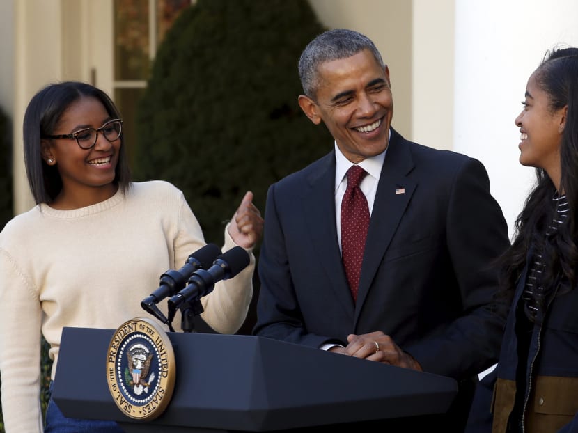 US President Barack Obama smiles next to his daughters Sasha (L) and Malia (R). Photo: REUTERS