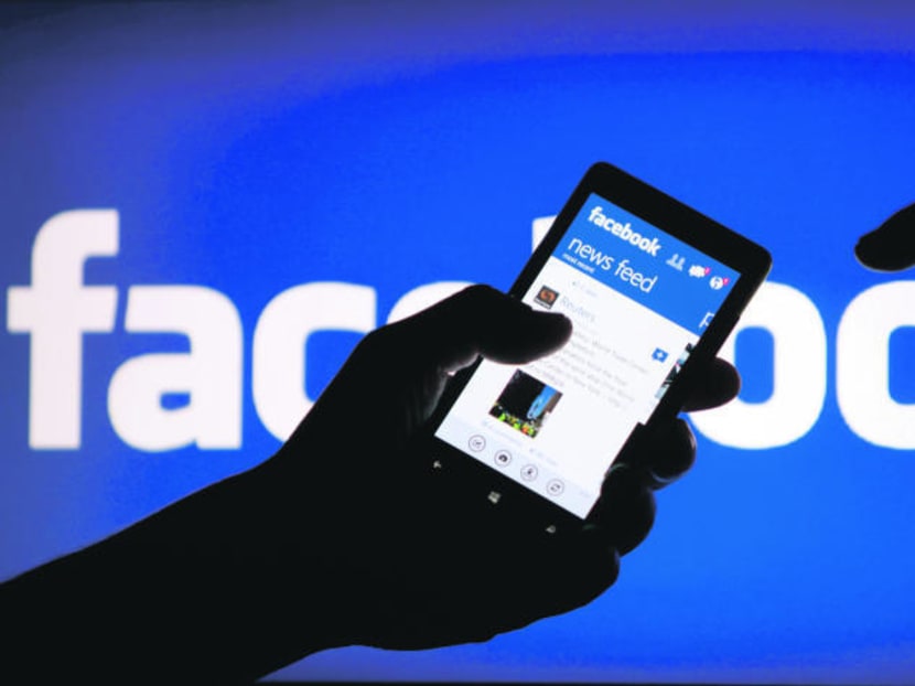 A smartphone user shows the Facebook application on his phone in this photo illustration, May 2, 2013. Photo: Reuters
