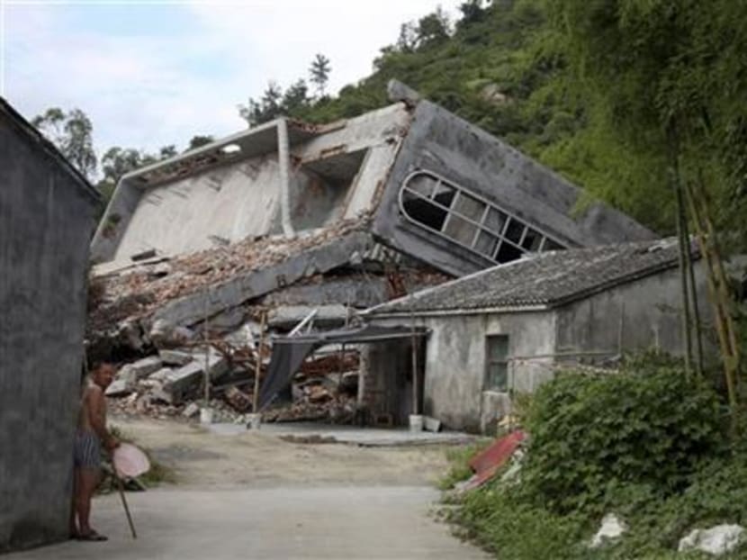 A man stands near the razed remains of a Catholic church in a village in Pingyang county of Wenzhou in eastern China's Zhejiang province on July 16, 2014. Photo: AP