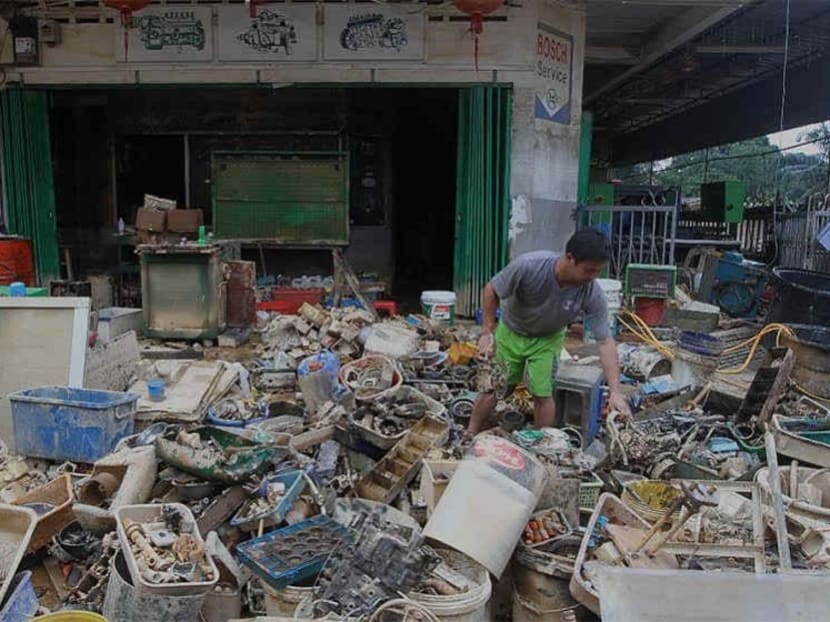 The owner of the shop, Kelvin Leong, 28, and his shop workers in Kuala Krai clear out their shop goods affected by the floods in Kelantan. Photo: The Malay Mail Online