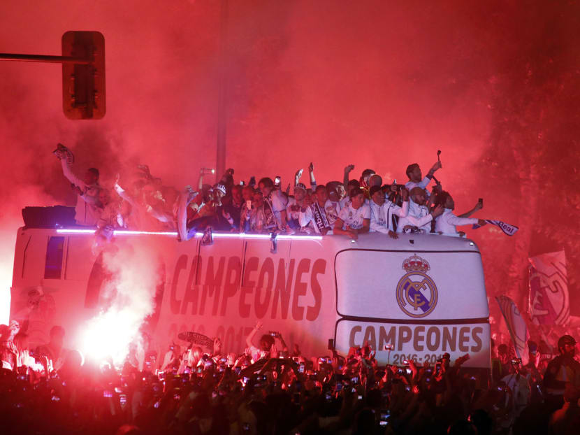 Real Madrid fans surrounding the bus as Real Madrid players celebrate the team's win on Plaza Cibeles in Madrid. Real’s 2-0 win over Malaga CF sealed a first La Liga title in five years on Sunday -- and 33rd in total -- to bring a halt to Barcelona's domination of domestic matters having won six of the previous eight titles. Photo: AFP
