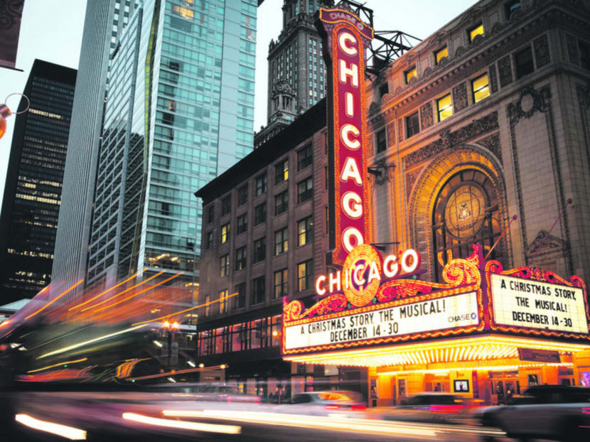 Evening rush hour traffic passes the iconic Chicago Theatre on North State Street in the Chicago Loop.