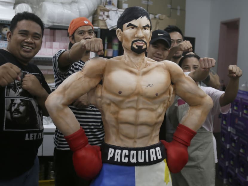 Zach Yonzon, second from right at the back, The Bunnybaker Cafe owner and artistic director and his crew pose with the life-sized cake of Filipino boxer Manny Pacquiao Saturday, May 2, 2015 at his bakeshop at suburban Quezon city northeast of Manila, Philippines. Photo: AP