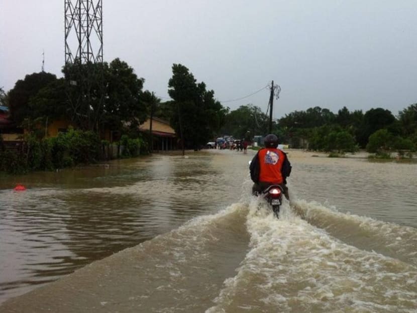 A motorist riding along a flooded street in Pahang, Malaysia. Photo: @nazrolnasir, Twitter