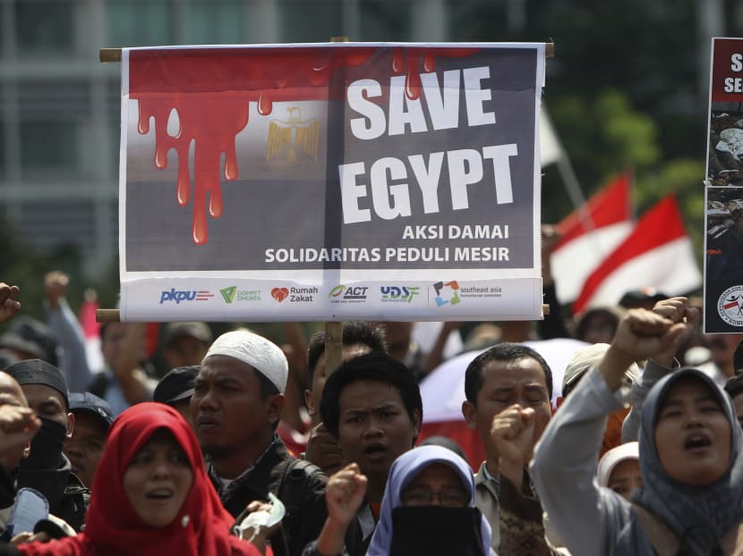 Indonesian Muslims display a poster during a rally calling for an end to the violence used against pro-Morsi protesters in Egypt, in Jakarta, Indonesia, Monday, Aug. 19, 2013. Photo: AP