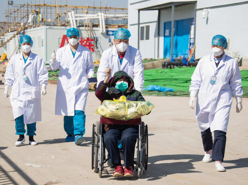 A recovered patient is discharged from Leishenshan Hospital in Wuhan in China's central Hubei province on Feb 18, 2020.