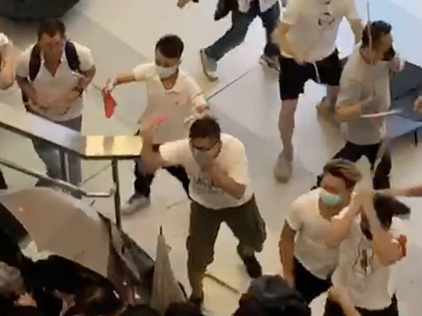 A screen grab from a video shows a group of people in white with wooden sticks chasing and assaulting passengers at the Yuen Long MTR station.