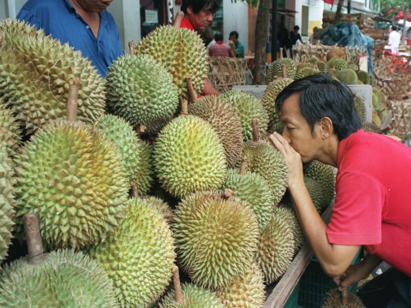 A customer leans forward to smell durians in Singapore. Reuters file photo