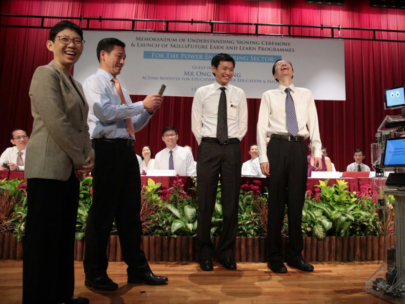 Ong Ye Kung, Minister for Education (Higher Education and Skills) taking a photo of Xuan, a student-created robot. The writer (second from the right) says that with technological disruptions, educators must now learn how to teach something that they have never been taught themselves. TODAY file photo