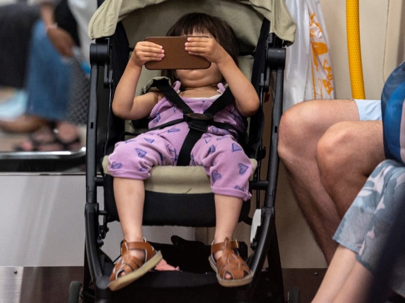 A toddler looks at a smartphone in a train in Tokyo on July 24, 2021. A toddler looks at a smartphone in a train in Tokyo on July 24, 2021.