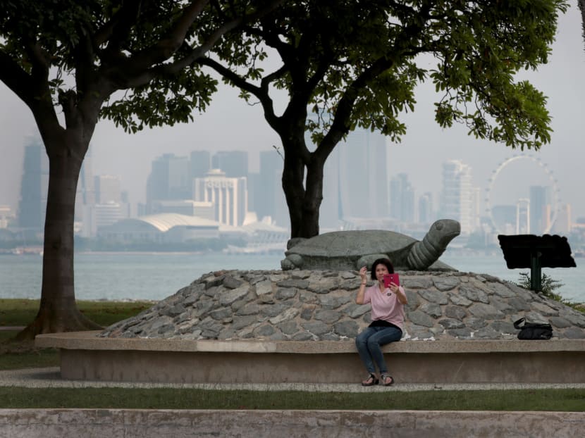 A woman takes a selfie with Kusu Island’s iconic tortoise sculpture, as the central business district skyline is seen in the background. The island is 15-20 minute boat ride away from the mainland.