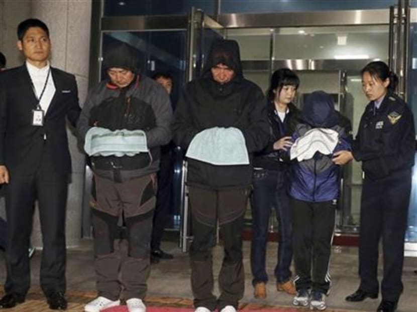 In this April 19, 2014 file photo, Lee Joon-seok (third from left), the captain of the ferry Sewol that sank off South Korea, and two crew members prepare to leave a court which issued their arrest warrant in Mokpo, south of Seoul, South Korea. Photo: AP
