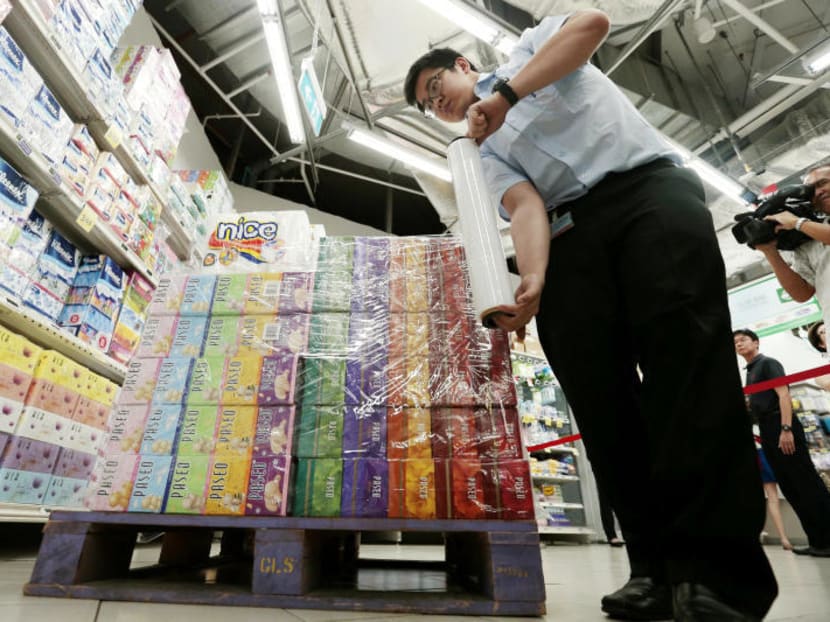 Fairprice staff moves paper products sourced from Asia Pulp & Paper Group, one of the six firms accused of causing forest fires in Indonesia. Photo: Jason Quah