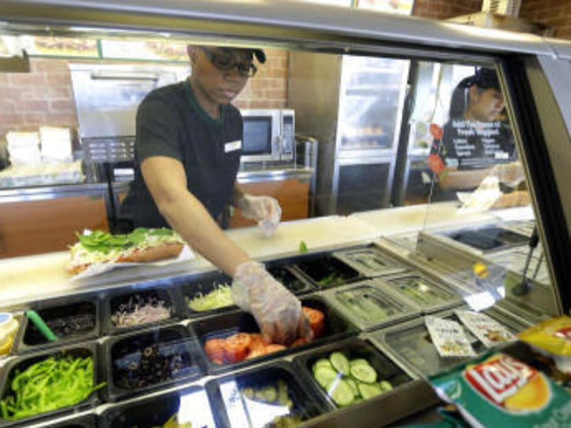Workers make sandwiches at a Subway sandwich franchise in Seattle in this March 3, 2015 photo. Photo: AP
