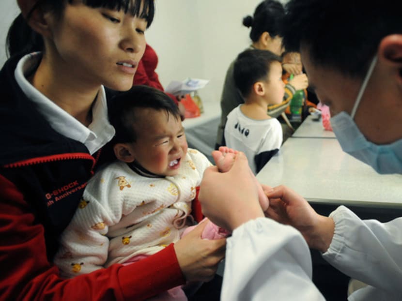 A doctor examines a child at a hospital in Hefei, Anhui province, China. The country has a shortfall of at least 200,000 paediatricians, according to the National Health and Family Planning Commission. Photo: REUTERS