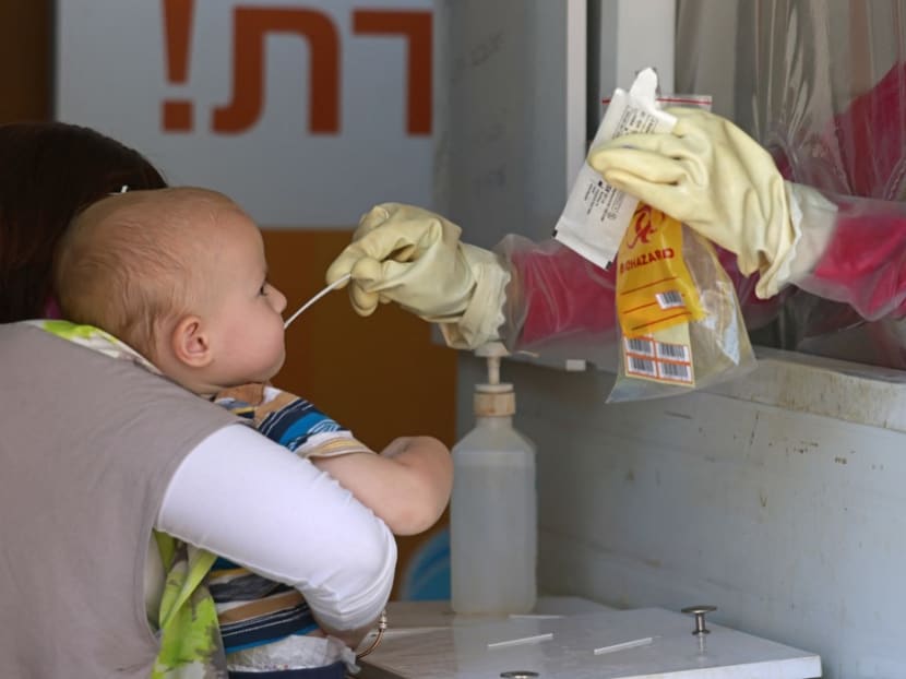 A medic performs a Covid-19 coronavirus swab test on a child in Jerusalem on Aug 1, 2021.