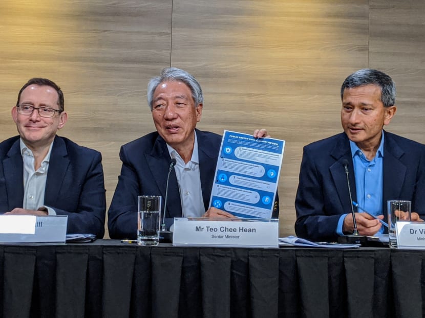 Senior Minister Teo Chee Hean holds up an infographic on the five recommendations by his committee to protect Singaporeans' data. Seen beside him are committee members (left) Mr David Gledhill, the former chief information officer at DBS; and Dr Vivian Balakrishnan, the Foreign Affairs Minister and Minister-in-charge of the Smart Nation initiative.