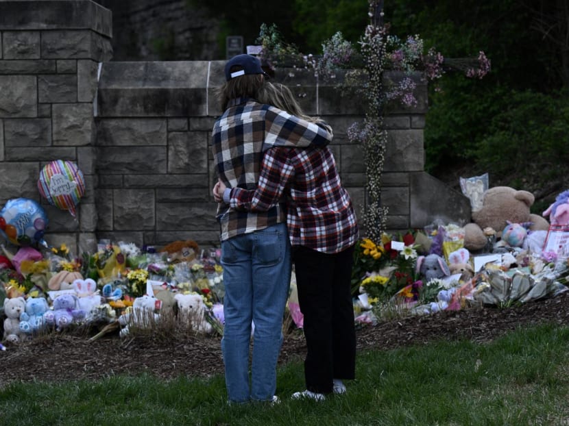 A couple pay their respects at a makeshift memorial for victims at the Covenant School building at the Covenant Presbyterian Church following a shooting, in Nashville, Tennessee, on March 28, 2023. 