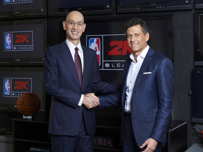 NBA Commissioner Adam Silver, left, and Take-Two CEO Strauss Zelnick posing for a photo at the NBA headquarters in New York. Video gamers now have a chance to compete for an NBA title, in an actual NBA arena and get paid by the some of the same people who pay LeBron James and Stephen Curry. PHOTO: NBA/AP