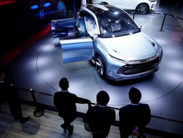 People stand near a BYD X Dream electric vehicle (EV) displayed during a media day for the Auto Shanghai show in Shanghai, China on April 19, 2021.
