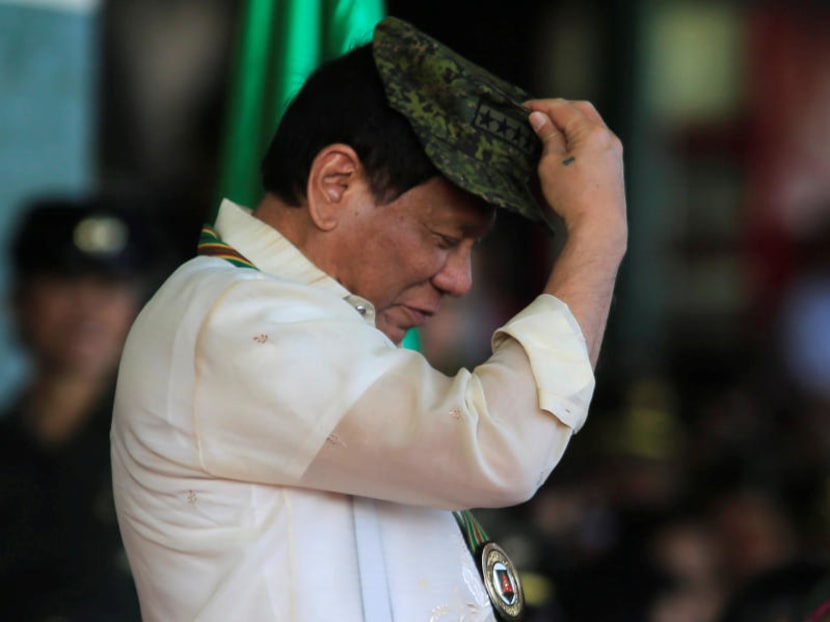 Philippine President Rodrigo Duterte trying on a military hat given to him during the 120th founding anniversary of the Philippine Army (PA) at Taguig City, metro Manila, Philippines on April 4, 2017. Photo: Reuters