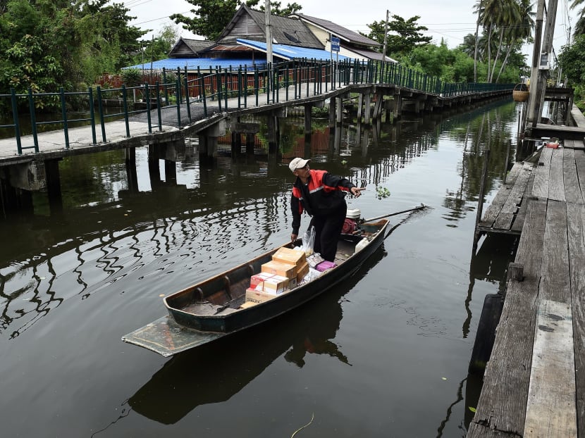 The boatman postman: Nopodal Choihirun goes on one of his rounds delivering mail to the riverside residents. Photo: AFP