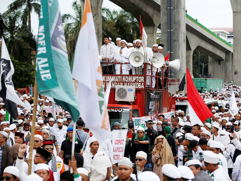 Members of the hardline Islamic Defenders Front group march with their leader, Rizieq Shihab, during a protest in Jakarta. Thanks to its networks both within political parties and security officials, FPI has gained influence in many provincial and regional local government elections. Photo: Reuters