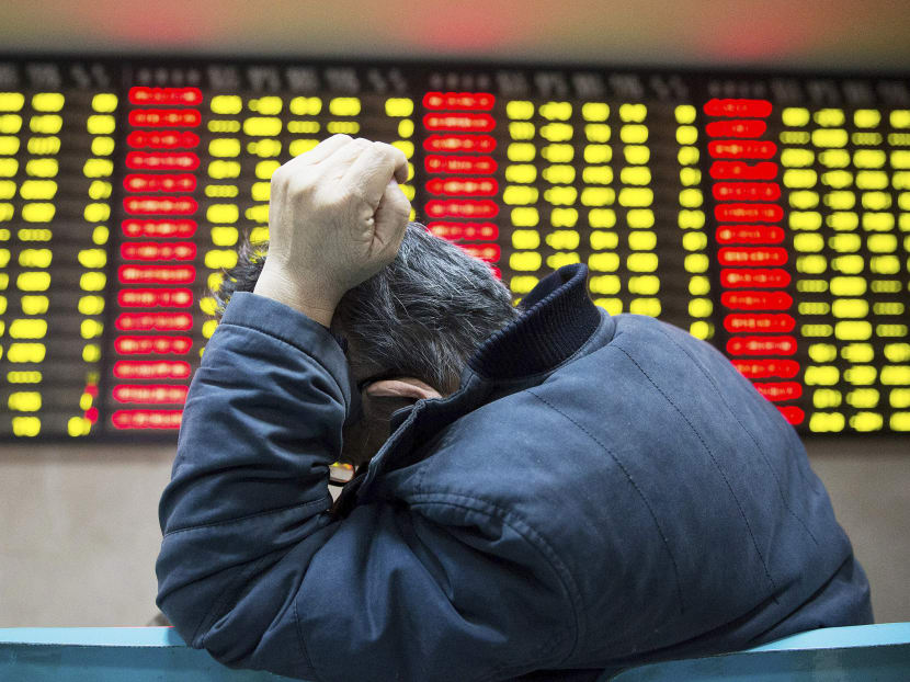 An investor sits in front of an electronic board showing stock information at a brokerage house in China. Photo: Reuters