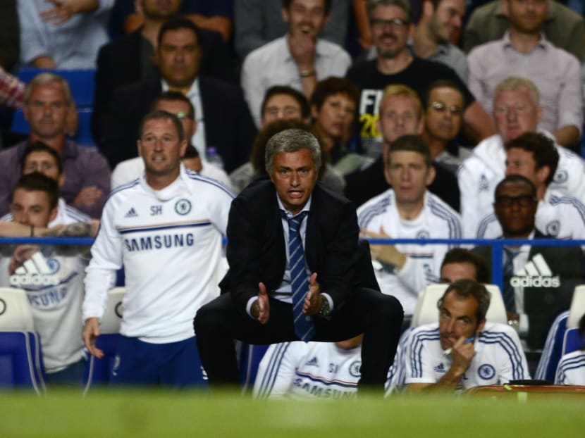 Chelsea's manager Jose Mourinho squats by the touchline during their English Premier League match against Aston Villa at Stamford Bridge in London on Aug 21, 2013. Photo: Reuters