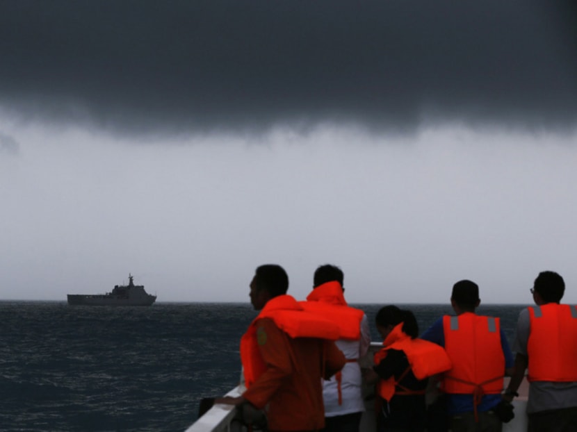 Rescue team members look out toward the ship KRI Banda Aceh as dark clouds fill the sky during a search operation for passengers onboard AirAsia Flight QZ8501 in the Java Sea January 4, 2015. Bad weather forced divers trying to identify sunken wreckage from the crashed AirAsia passenger jet to abort their mission on Sunday and Indonesian officials said they had not yet picked up any signals from the lost plane's "black box". Photo: Reuters