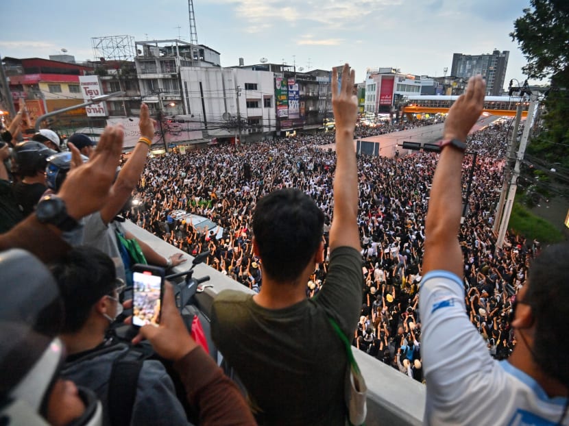 Pro-democracy protesters give the three-finger salute during an anti-government rally at Kaset intersection in Bangkok on Oct 19, 2020, as they continue to defy an emergency decree banning gatherings.