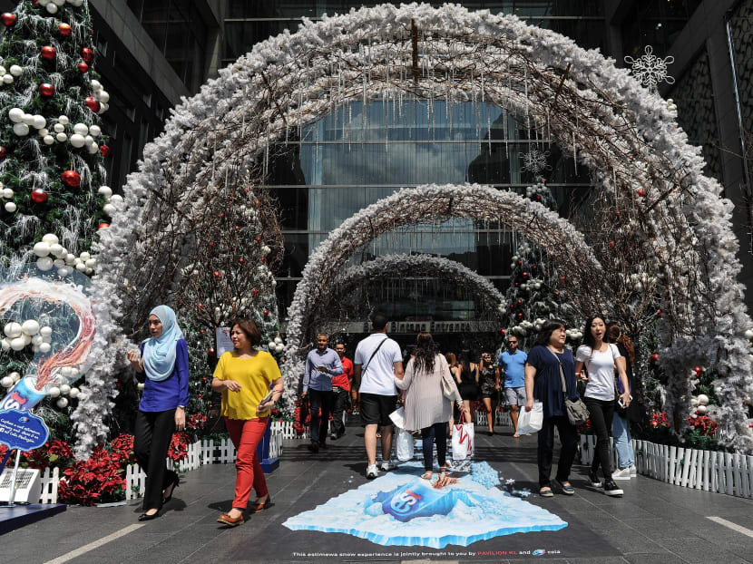 Shoppers walk under Christmas decorations at a shopping mall in Kuala Lumpur on December. Malaysia’s economy grew at the fastest pace in more than three years in the third quarter, supported by resilient domestic demand and strong exports. Photo: AFP