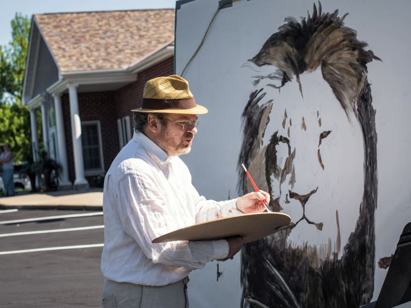 Artist Mark Balma paints a mural of Cecil, a well-known lion killed by Minnesota dentist Walter Palmer during a guided bow hunting trip in Zimbabwe, as part of a silent protest outside Dr Palmer's office in Bloomington, Minnesota, Wednesday, July 29, 2015. Photo: AP