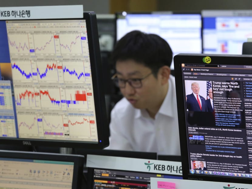 A currency trader watches monitors at the foreign exchange dealing room in Seoul, South Korea. Shares in Asia outside Japan climbed on Monday (Aug 14) together with US equity-index futures. Photo: AP