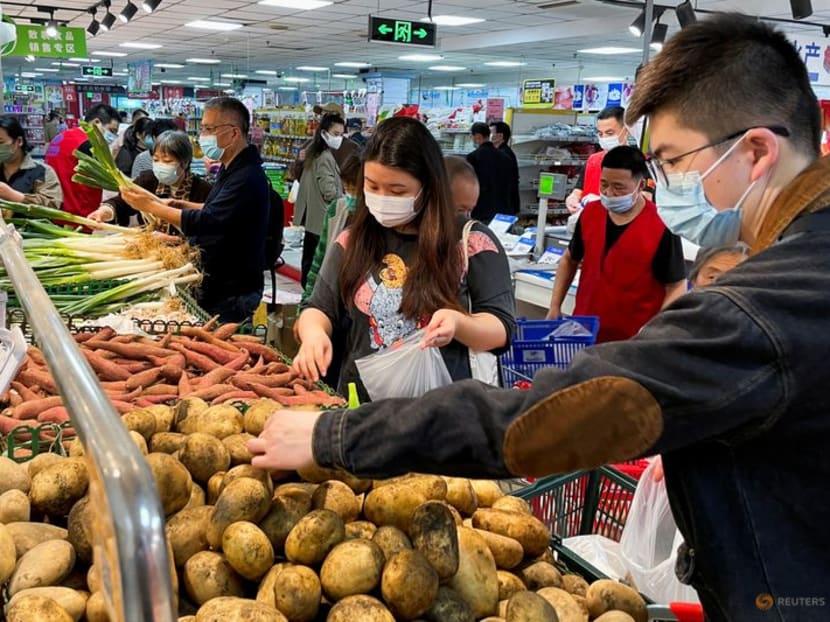 FILE PHOTO: Customers wearing face masks shop at the vegetables section of a supermarket following the coronavirus disease (COVID-19) outbreak in Beijing, China April 25, 2022. REUTERS/Carlos Garcia Rawlins