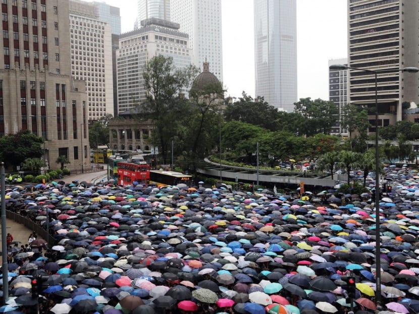 Umbrellas go up in Central, Hong Kong, as thousands of teachers brave heavy rain to show solidarity with their students.