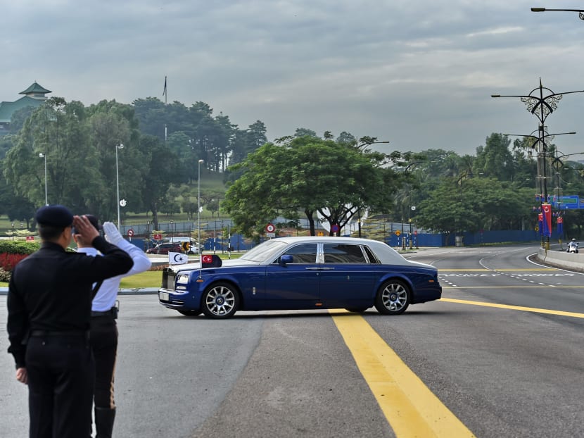 Malaysian policemen salute as a Rolls-Royce belonging to the Sultan of Johor enters the Istana Bukit Serene palace in Johor Bahru for the wedding. Photo: AFP