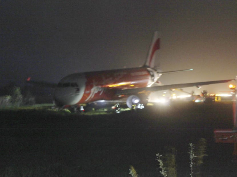 An Air Asia passenger plane sits on the grassy portion of the runway after overshooting upon landing in windy weather at Kalibo airport in Kalibo township, Aklan province in central Philippines today. Photo: AP
