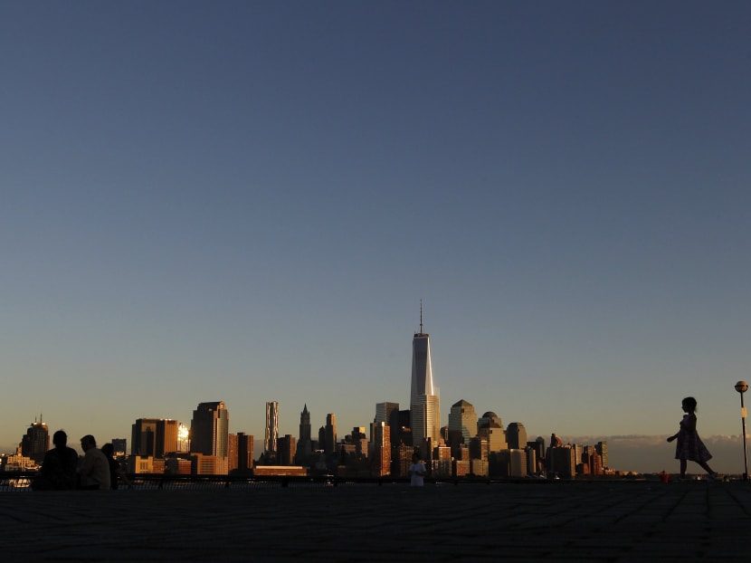 A girl plays in front of the skyline of New York's Lower Manhattan and One World Trade Center in a park along the Hudson River in Hoboken, New Jersey, September 5, 2013. New York will mark the 12th anniversary of the 9/11 attack on the World Trade center next week. Photo: Reuters