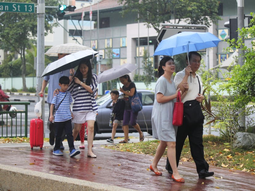 Pedestrians seeking shelter from the morning rain..Photo: Ernest Chua. 26 June 2013.