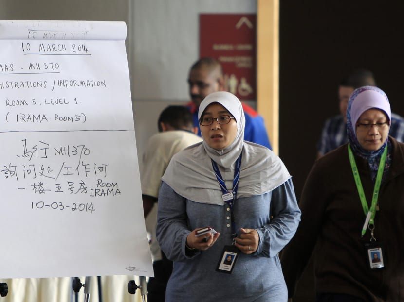 Malaysia Airlines officers walk past a notice board for families and friends of passengers aboard a missing plane at a hotel in Putrajaya, Malaysia, Monday, March 10, 2014. Photo: AP