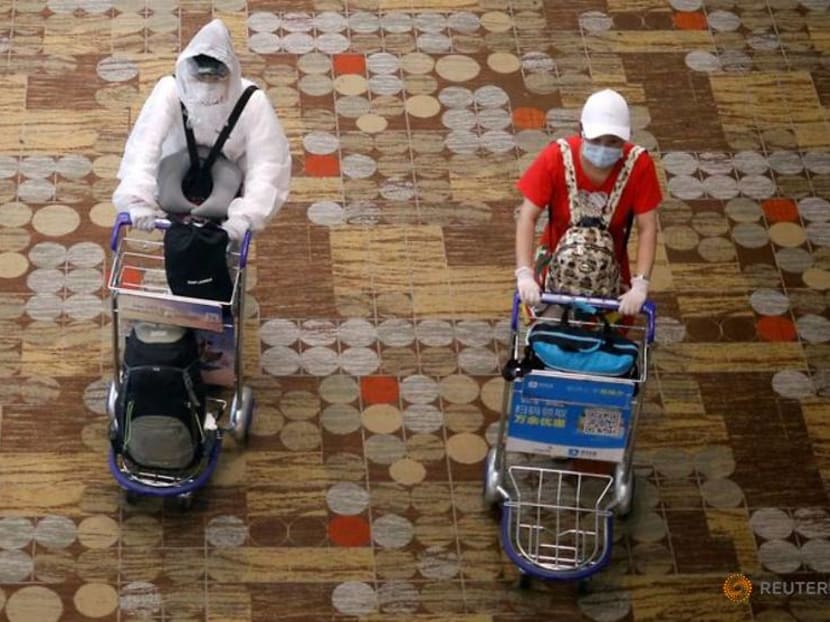 Travellers wearing protective gear are seen at Changi Airport in Singapore.