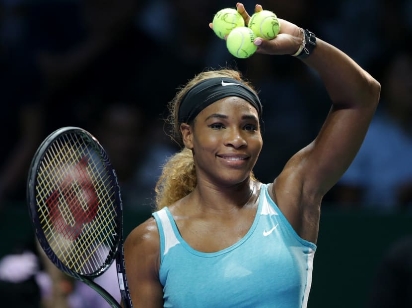 Serena Williams of the US prepares to hit autographed balls into the crowd following her win over Canada's Eugenie Bouchard during their singles match at the WTA tennis finals in Singapore,Thursday, Oct 23, 2014. Photo: AP