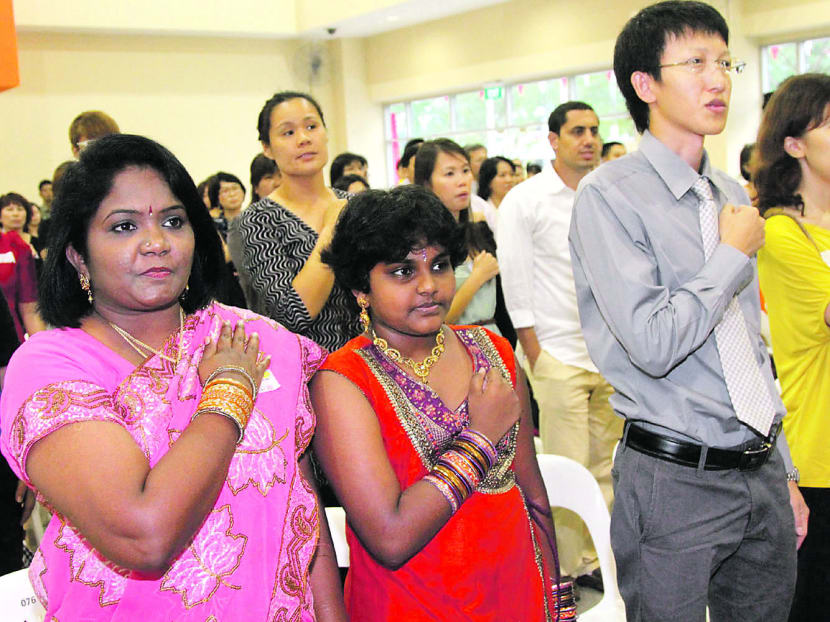 New citizens reciting the Pledge after being presented their Singapore identity cards. TODAY file photo