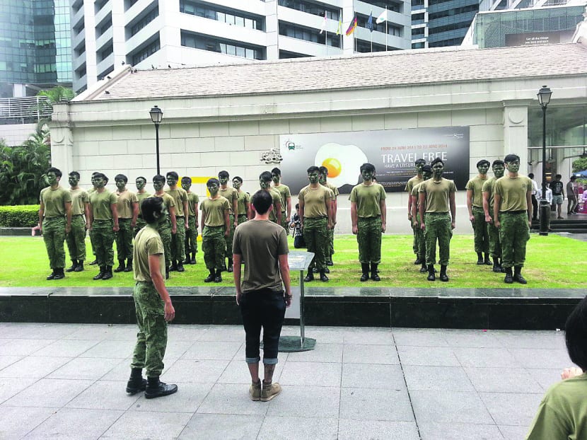 The channel hired actors who donned SAF uniforms and marched around Raffles Place yesterday, inviting passersby to deliver drill commands to the ‘platoon’. Photo: National Geographic Channel Singapore
