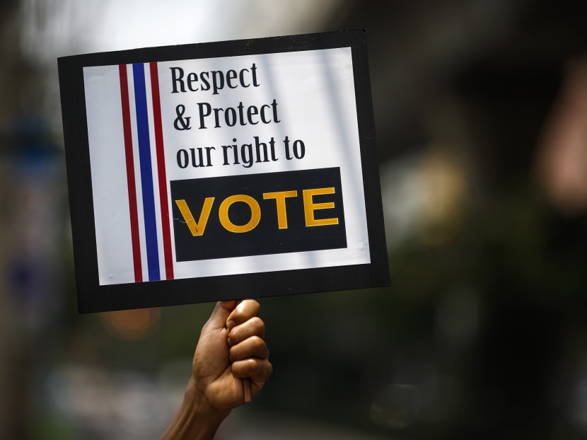 A man holds a placard during a rally demanding the people's votes to be respected, while protesting against the court's ruling in central of Bangkok March 21, 2014. Photo: REUTERS
