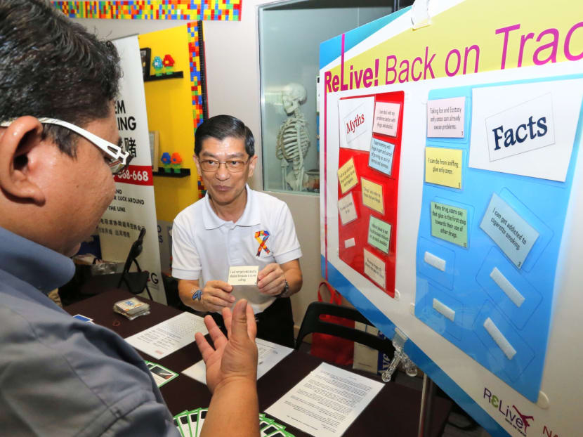 An Institute of Mental Health officer speaking to a visitor about addiction myths at today's (Nov 22) launch of the new platform by the National Addictions Management Service. Photo: Ernest Chua